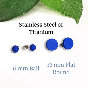 May include: A selection of blue stud earrings in two styles: 6 mm ball and 12 mm flat round. The earrings are made of stainless steel or titanium. Text on the image reads "Stainless Steel or Titanium".