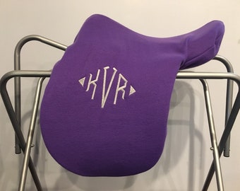 May include: Purple fleece saddle pad with the monogram "KVR" embroidered in white.
