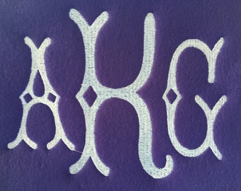 May include: White embroidered letters "AKC" on a purple background.