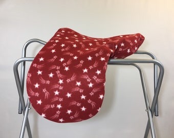 May include: Red fleece saddle pad with a white shooting star pattern.