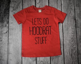 May include: Red short-sleeved t-shirt with black text that reads "Lets do hoodrat stuff".