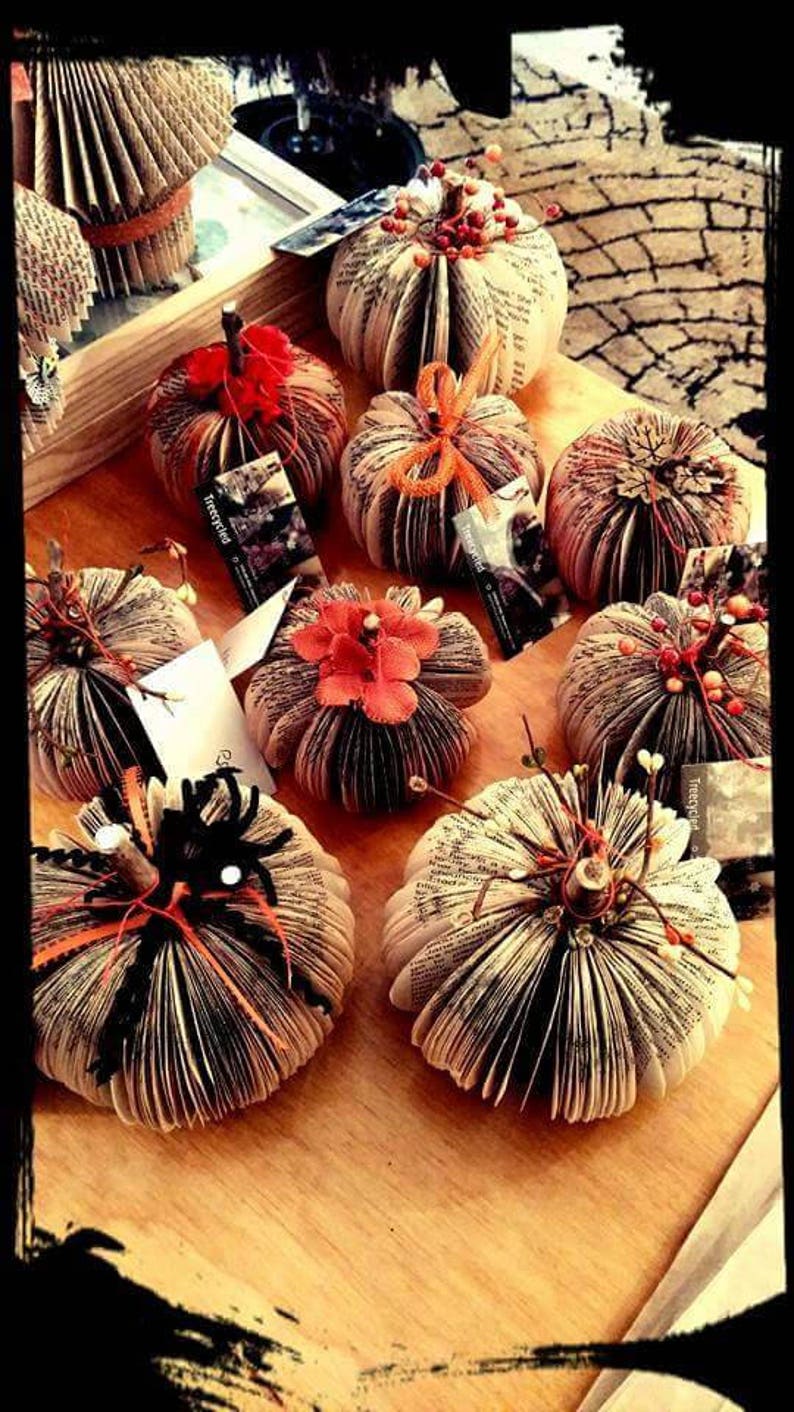 Pumpkins made from book pages, various embellishments such a pine cones,  berries or twine.  The pumpkins stem is made from a twig branch. Colors available are natural book color, orange,  pink, purple or teal.