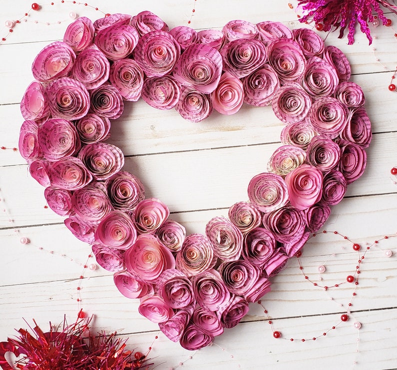 Heart shaped wreath covered in book page roses. This version is done in fuchsia ombre
