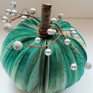 Teal book page pumpkin with silver berries as embellishments