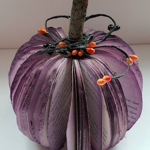 Purple book page pumpkin with black and orange berries as embellishments