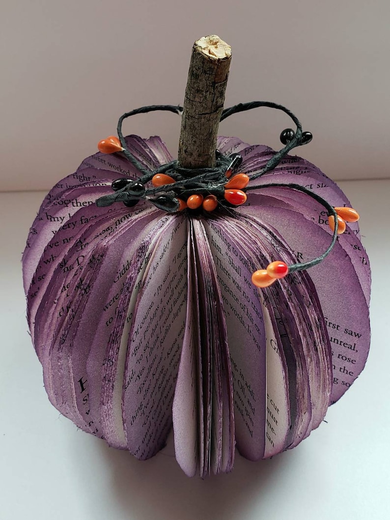 Purple book page pumpkin with black and orange berries as embellishments