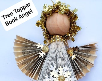 May include: A book page angel tree topper with gold glitter wings and a wooden head. The angel is decorated with a gold snowflake and gold glitter.