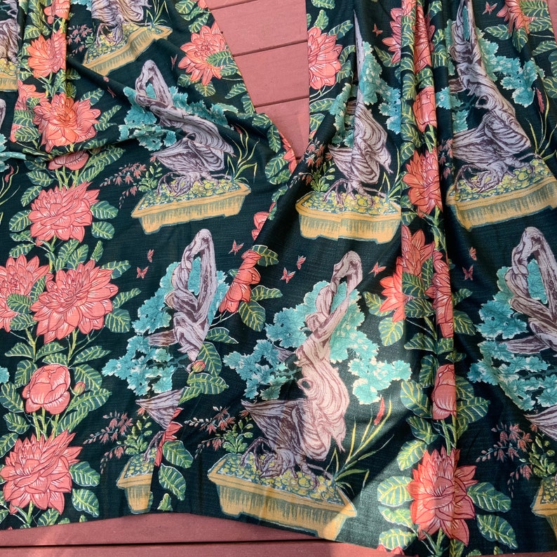 May include: Black fabric with a repeating pattern of pink flowers, green leaves, and stylized birds in pots. The fabric has a textured, almost quilted look.