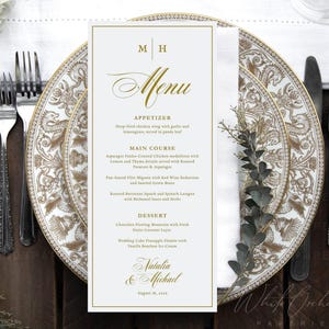 Może przedstawiać: Pionowa biała karta menu ze złotym tekstem i obramowaniem, zawierająca inicjały M H na górze, słowo Menu pisane kursywą oraz sekcje Appetizer, Main Course i Dessert, kończąca się imionami Natalia & Michael oraz datą 18 sierpnia 2023 roku.