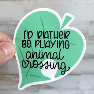 May include: A green leaf-shaped sticker with the text "I'd rather be playing animal crossing" in black.