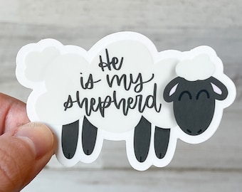 May include: White sticker with a black and white cartoon sheep. The sheep has the text "He is my shepherd" written on it.