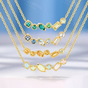 Puede incluir: Cinco collares de oro con piedras preciosas de diferentes colores. Cada collar presenta una fila curva de piedras preciosas de varias formas y tamaños. Las piedras preciosas incluyen verde esmeralda, azul claro, naranja y ópalo blanco.