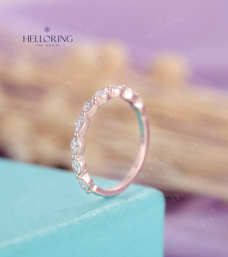 May include: A delicate rose gold band with a row of marquise-shaped diamonds set in a pave setting.