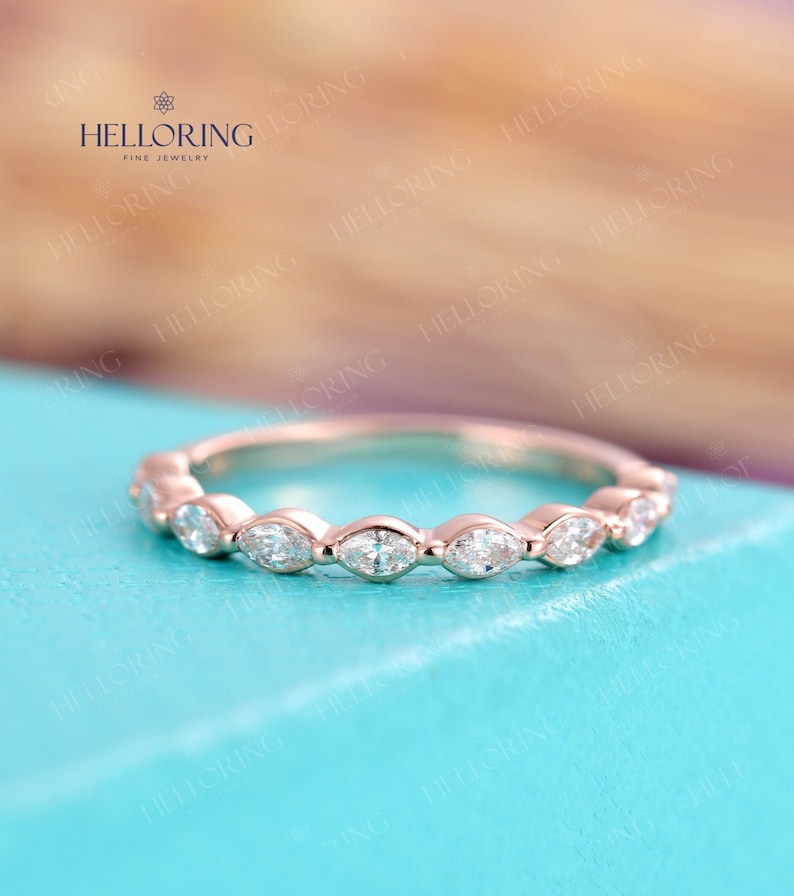 May include: A delicate rose gold band with a row of marquise-shaped diamonds set in a scalloped design.