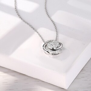May include: A silver chain necklace with a pendant featuring a circle of sparkling cubic zirconia stones.