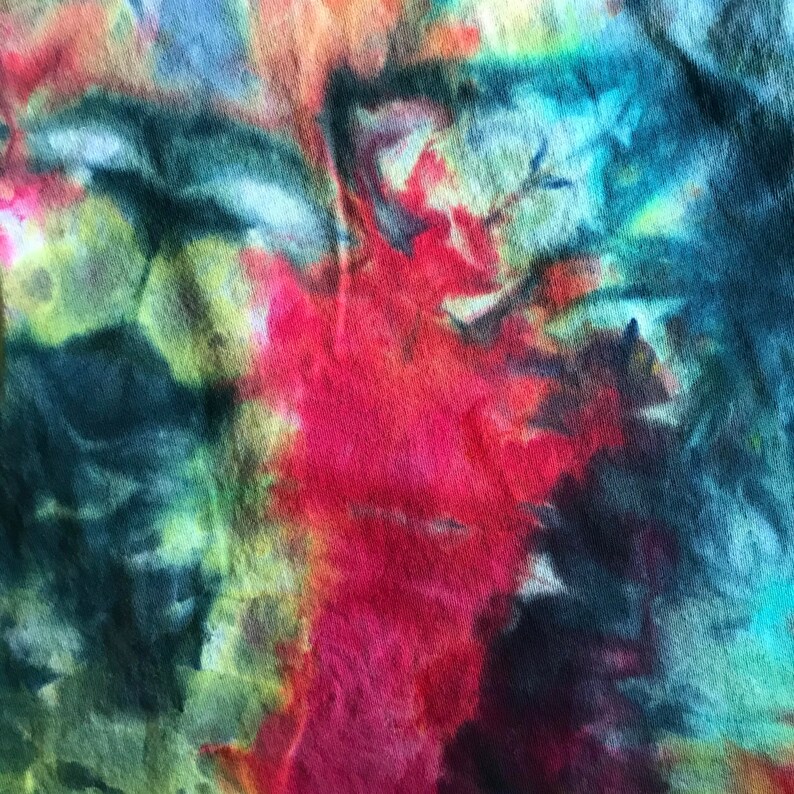 Pode incluir: Padr&atilde;o abstrato tie-dye em tons de azul, verde, vermelho e amarelo. O tecido tem uma textura enrugada.