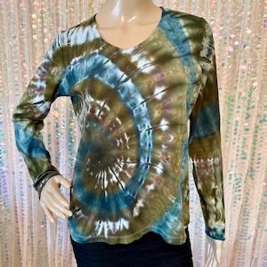 May include: A long-sleeved V-neck shirt with a tie-dye pattern in shades of blue, green, and brown. The shirt's design features a spiral pattern, with the colors blending together. The shirt is made of a soft material.
