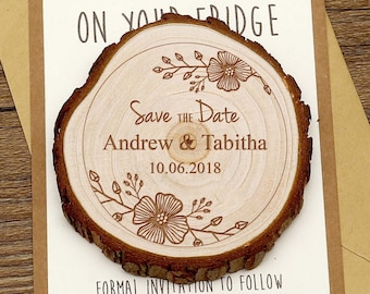 May include: A wooden save the date magnet with a rustic woodgrain finish. The magnet features a floral design and the text "Save the Date" with the names "Andrew & Tabitha" and the date "10.06.2018". The magnet is attached to a card that reads "Put me on your fridge" and "Formal invitation to follow".