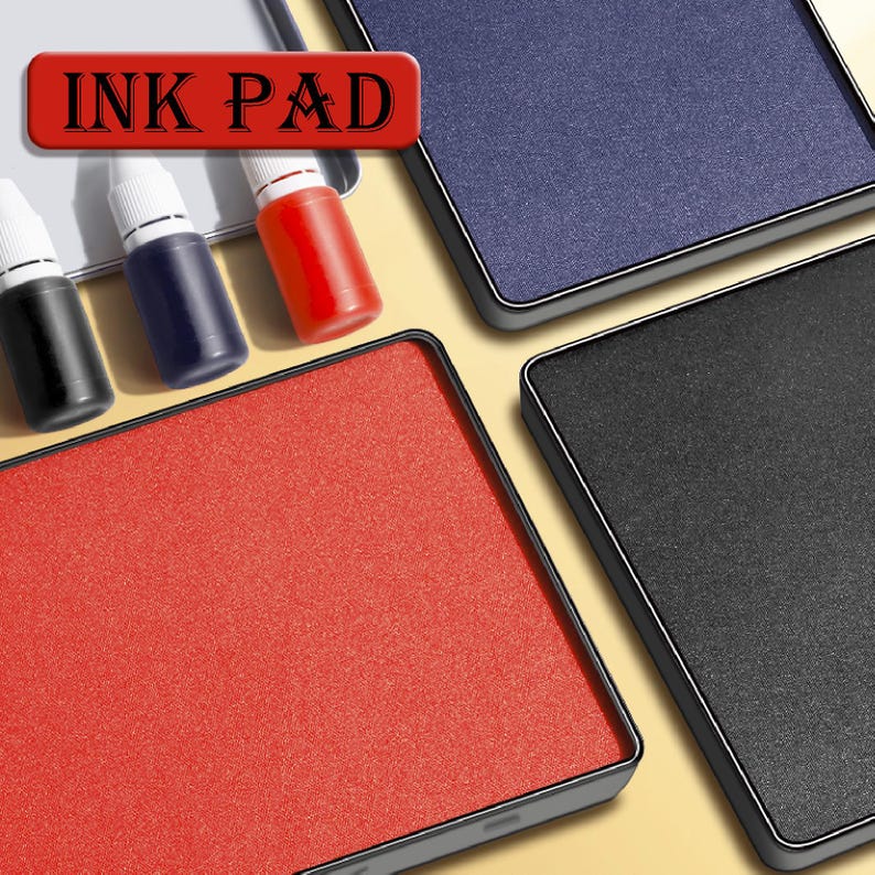May include: Ink pads in red, blue, and black, with matching ink bottles. The image shows four ink pads with a rectangular shape and a dark border. The text "INK PAD" is displayed in a red rectangle.