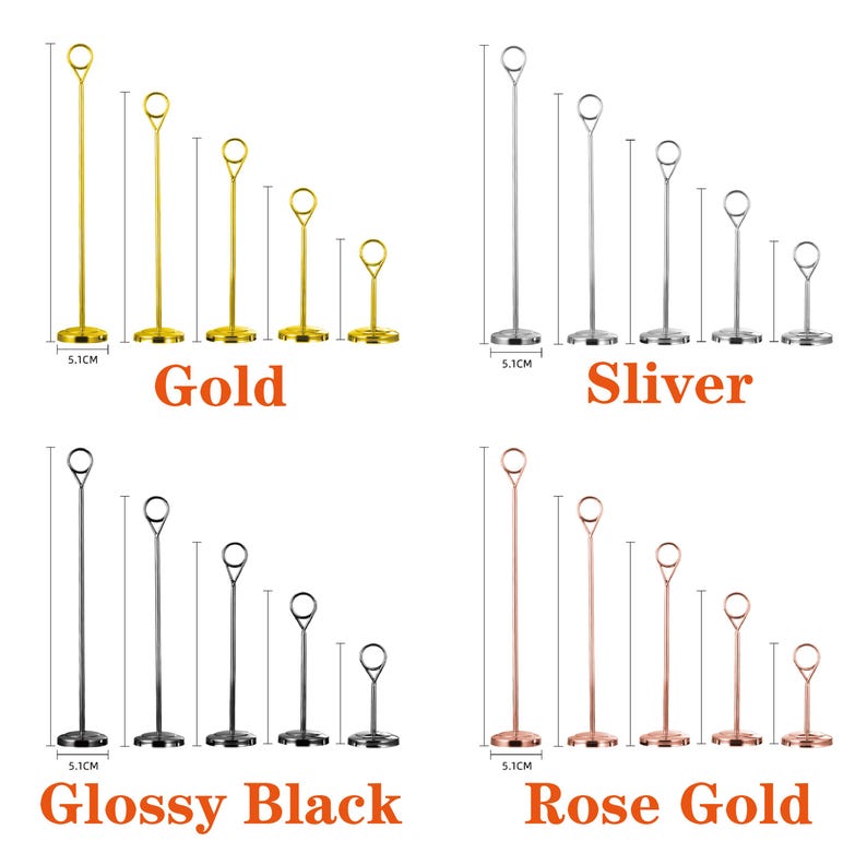May include: A collection of metal table number holders in gold, silver, glossy black, and rose gold. Each set includes five holders of varying heights, with a circular ring at the top for holding cards. The base of each holder is 5.1 cm in diameter.