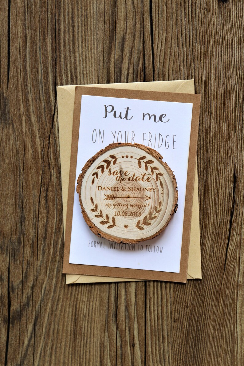 May include: A wooden save the date magnet with the text "Save the date" and the names "Daniel & Shauney" with the date "10.08.2018". The magnet is on a white card with the text "Put me on your fridge" and "Formal invitation to follow".