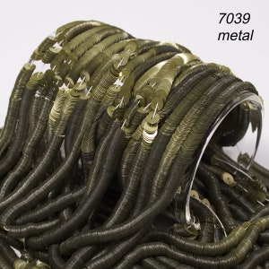May include: Close-up of olive green metal sequins, strung together in long strands. The sequins are circular and have a metallic sheen. The text "7039 metal" is visible in the upper right corner. The sequins are displayed on a clear, curved surface.