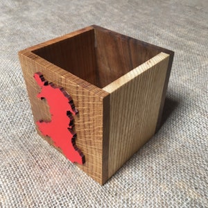 May include: A wooden box with a red outline of Wales on the front. The box is made of different types of wood, including oak and walnut.