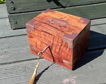 Hucha de estilo victoriano, de madera noble y latón, con cerradura y llave.