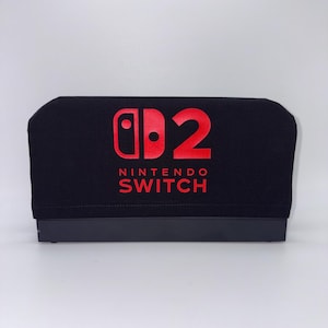 May include: Black cover with red "D2 Nintendo Switch" logo. The cover is designed to fit a Nintendo Switch console. The text and logo are centered on the cover.