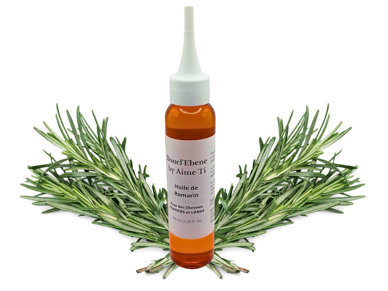 May include: A brown glass bottle with a white dropper top filled with a clear amber liquid. The bottle is labeled "Boucl'Ebene by Aime'Ti Huile de Romarin Pour des Cheveux Secs et Longs 100 ml (3.38 fl. oz)". The bottle is surrounded by sprigs of rosemary.