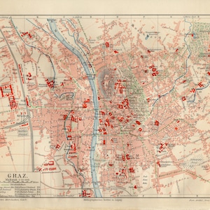 Könnte beinhalten: Eine Vintage-Karte von Graz, Österreich, im Maßstab 1:22.000. Die Karte zeigt ein Raster, wobei die Gebäude der Stadt rot und der Fluss Mur durch die Mitte verlaufen. Die Karte enthält Text auf Deutsch.