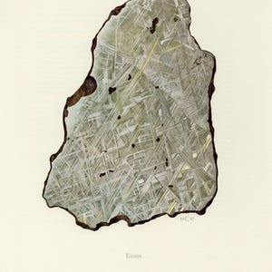 May include: Illustration of a slice of a meteorite, featuring a complex geometric pattern of intersecting lines and shapes in shades of gray and yellow. The outer edge is dark brown. The word "EISEN" is printed at the bottom, with "19 C 67" in the corner.