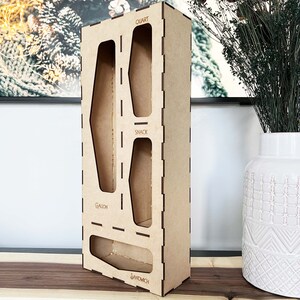 May include: A wooden organizer with four compartments for storing different sizes of containers. The compartments are labeled "Gallon", "Snack", "Quart", and "Sandwich".