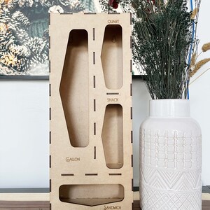 May include: A wooden organizer with four compartments for storing different sized containers. The compartments are labeled "Gallon", "Snack", "Quart", and "Sandwich".