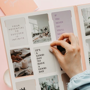 May include: A light pink journal with a white interior featuring photo inserts and inspirational quotes. The journal includes the text "Your potential to succeed is infinite" and "It's a good day to have a good day."