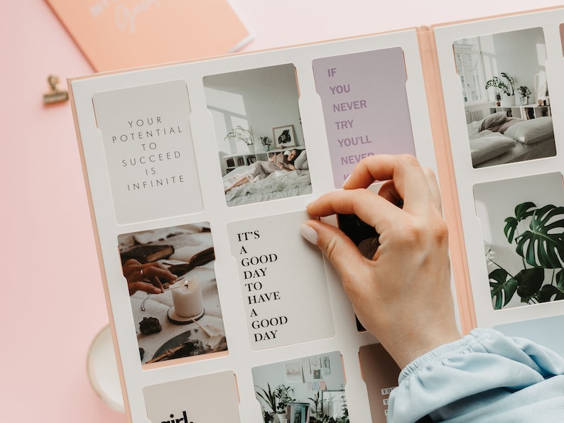May include: A light pink journal with a white interior featuring photo inserts and inspirational quotes. The journal includes the text "Your potential to succeed is infinite" and "It's a good day to have a good day."