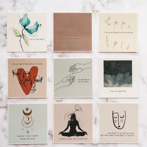 May include: Nine square cards with inspirational quotes and illustrations. The cards feature a variety of designs, including flowers, hands, stars, and moons. The quotes are positive and uplifting, such as "I am just pure magic" and "I trust my inner voice".
