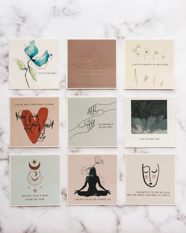 May include: Nine square cards with inspirational quotes and illustrations. The cards feature a variety of designs, including flowers, hands, stars, and moons. The quotes are positive and uplifting, such as "I am just pure magic" and "I trust my inner voice".