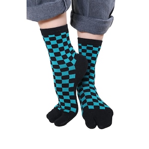 May include: Black and teal checkered socks with a split toe design. The socks are knee-high and feature a repeating checkerboard pattern. The socks are worn with gray pants.
