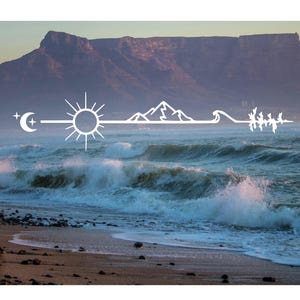 Op de afbeelding: Een foto van een strand met oceaangolven en een berg op de achtergrond. Een witte lijntekening van een maan, zon, bergen en bomen is over de afbeelding geplaatst.