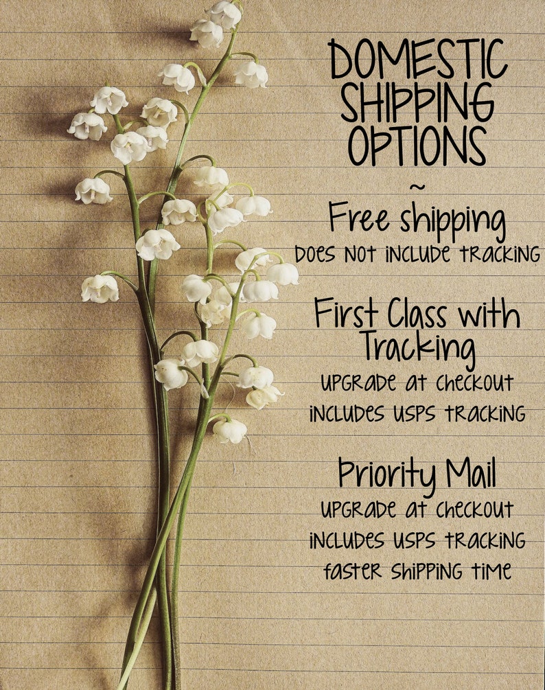 May include: A close-up of a handwritten note on lined paper with the text "Domestic Shipping Options" and details about free shipping, first class shipping with tracking, and priority mail. The note is decorated with a bouquet of white lily of the valley flowers.