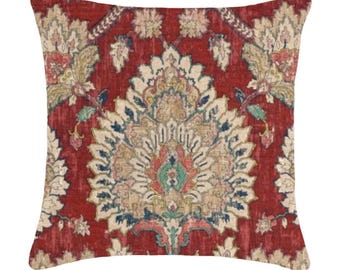 May include: Red throw pillow with a large, intricate floral pattern in shades of beige, blue, and green. The pattern is reminiscent of a traditional Persian rug.