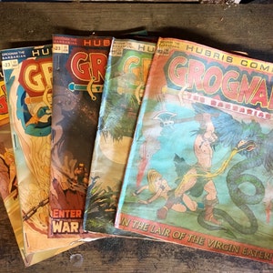May include: A stack of vintage comic books featuring the character Grognak the Barbarian. The covers are colourful and feature illustrations of Grognak fighting mythical creatures. The text on the covers reads "Grognak the Barbarian" and "Hubris Comics".