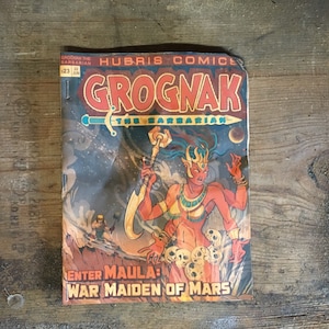 May include: A vintage comic book cover featuring a red-skinned female warrior with a sword and a skull-covered throne. The title is "Grognak the Barbarian" and the tagline is "Enter Maula: War Maiden of Mars".