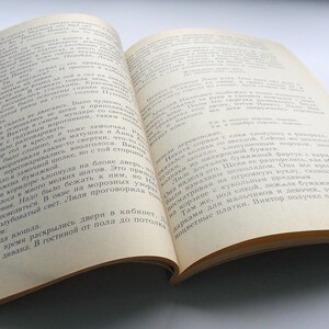 May include: Open book with white pages and black text. The text is in Russian. The book is open to a page with the text "Звезда взошла" and "СОСКОЧИЛИ с дивана. В гостиной от пола до потолка..."
