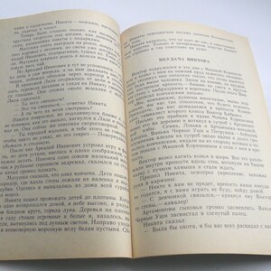May include: A vintage book with a worn, yellowed cover. The title of the book is "The Misadventures of Victor". The text on the page describes a group of children playing a game of war.