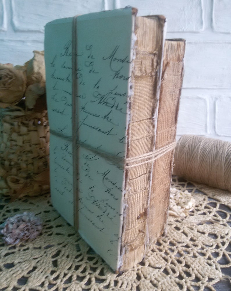 May include: Two antique books bound in brown leather with a handwritten note on the front cover. The books are tied together with twine.