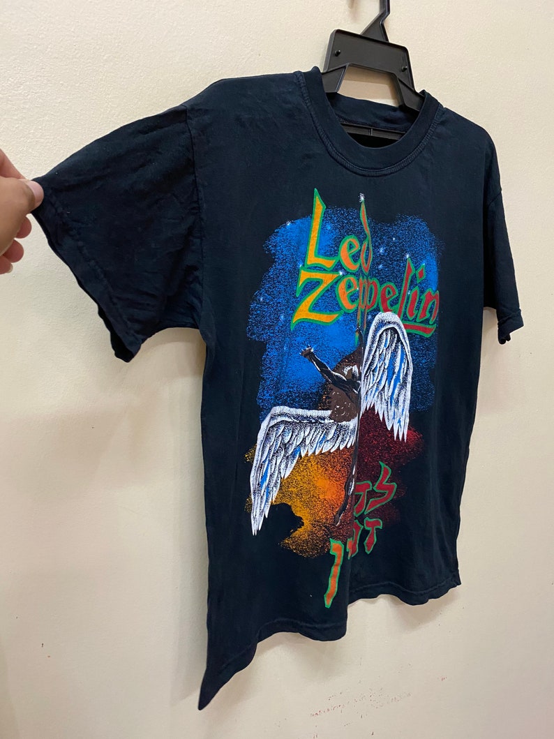 Op de afbeelding: Zwart T-shirt met een kleurrijke grafische print van een gevleugelde figuur en de tekst "Led Zeppelin".