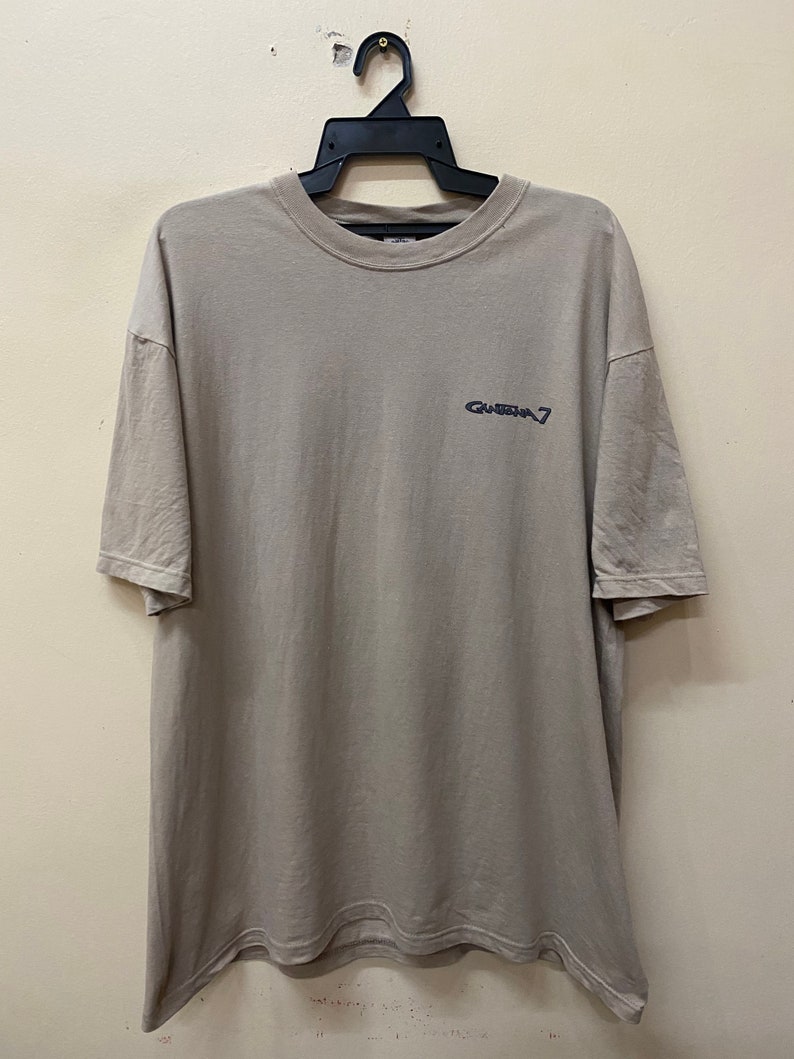 Może przedstawiać: Jasnoszary t-shirt z czarnym nadrukiem "Grateful 7" z przodu.