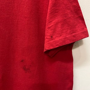 May include: A red t-shirt with a few small stains.